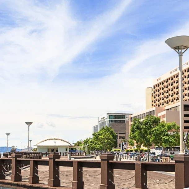 Daytime view of the Kota Kinabalu waterfront promenade under bright midday sunlight with seaside walkway and ocean views- feature image for walkable kota kinabalu blog