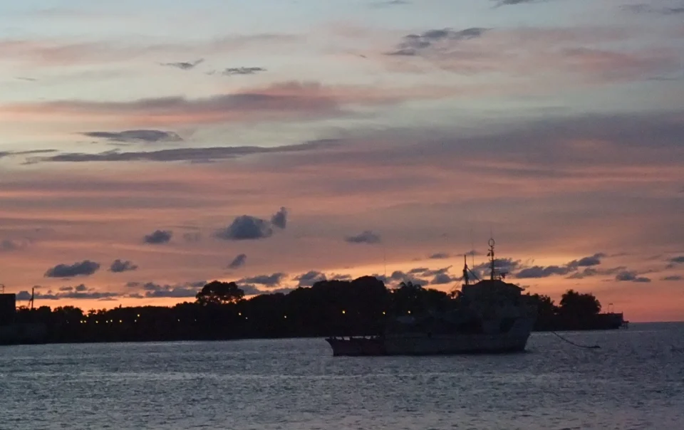 Sunset over KK Waterfront in Kota Kinabalu, with golden-orange sky and calm sea views
