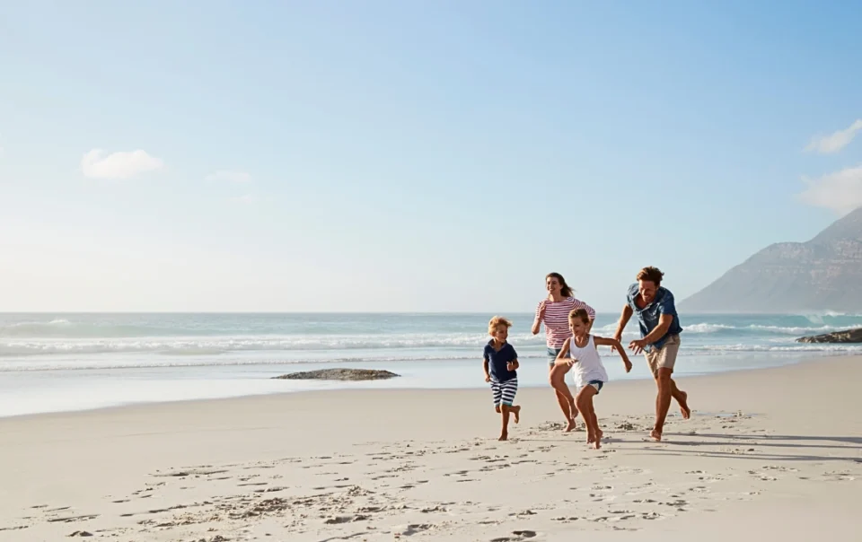A family playing on the sandy beach in Kota Kinabalu, enjoying a fun-filled day by the sea