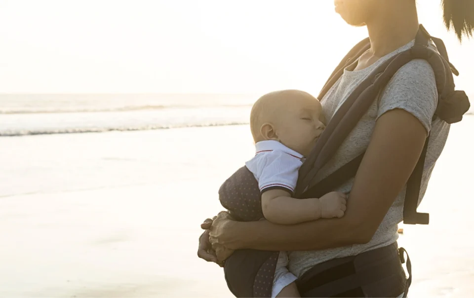 Mother carrying a baby in a front carrier