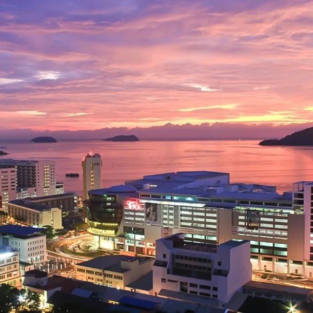 Kota Kinabalu city skyline by the sea just after sunset with a purple-blue sky